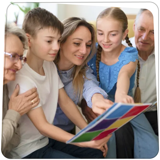 Gyerekek és nagyszülők közösen lapozzák a Rajzkönyvet, mosolygó családi pillanat.